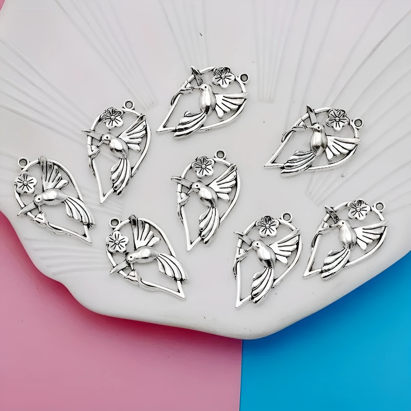 Close-up of a silver-toned alloy magpie bird pendant charm with electroplated finish, shown from the front.