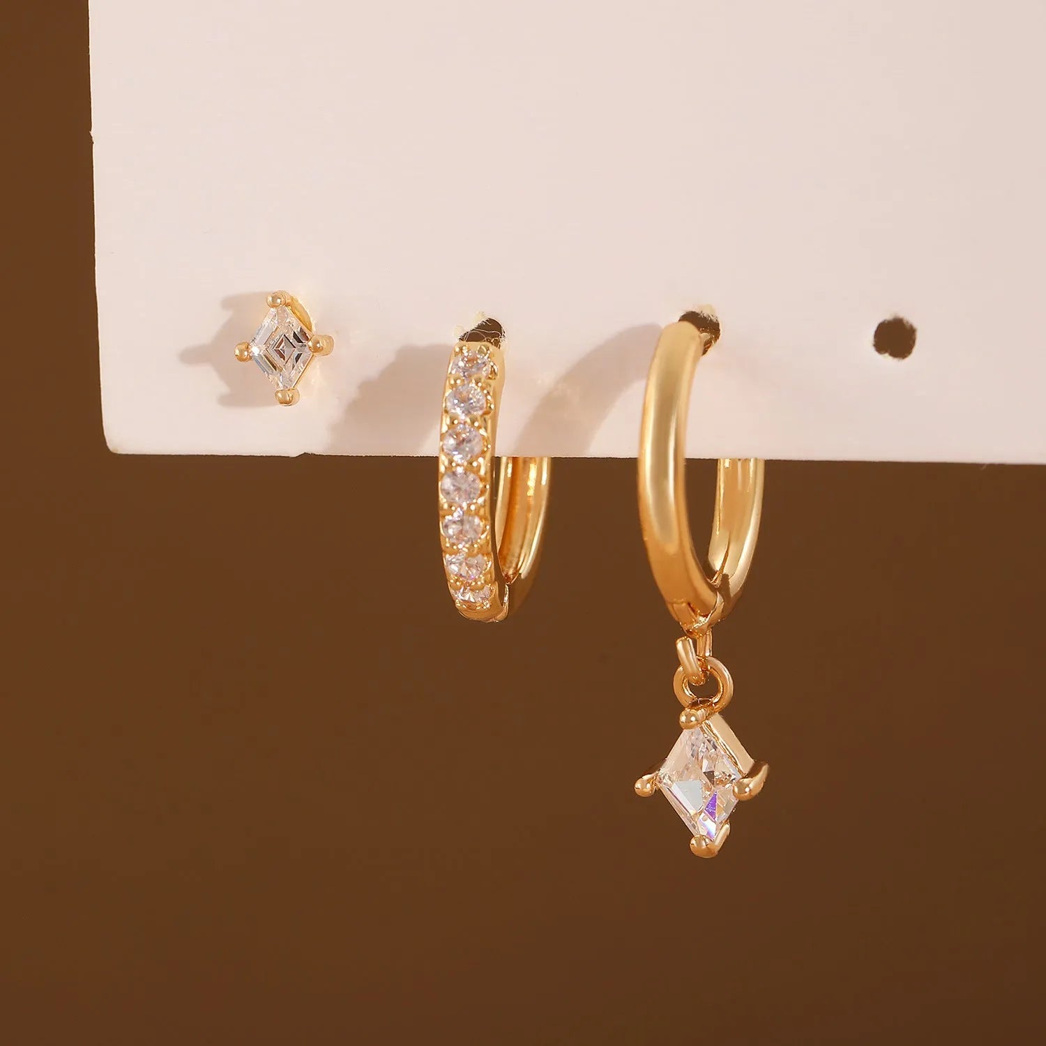 Ladies geometric zircon earring three-piece set in gold and silver colours showing pendant, stud, and clip styles