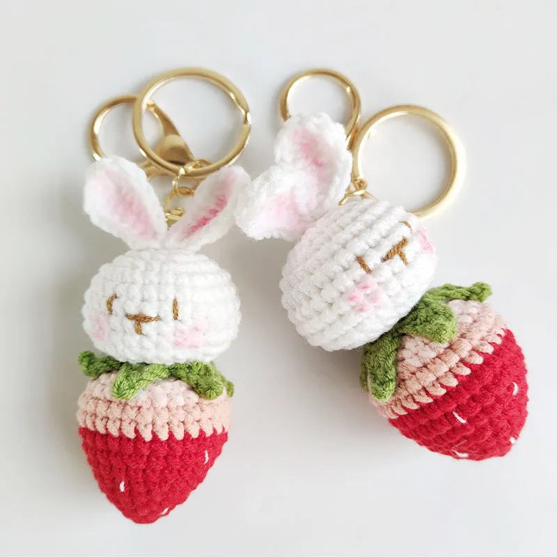Hand-woven white wire pendant charm with a cartoon rabbit and strawberry design on a key.