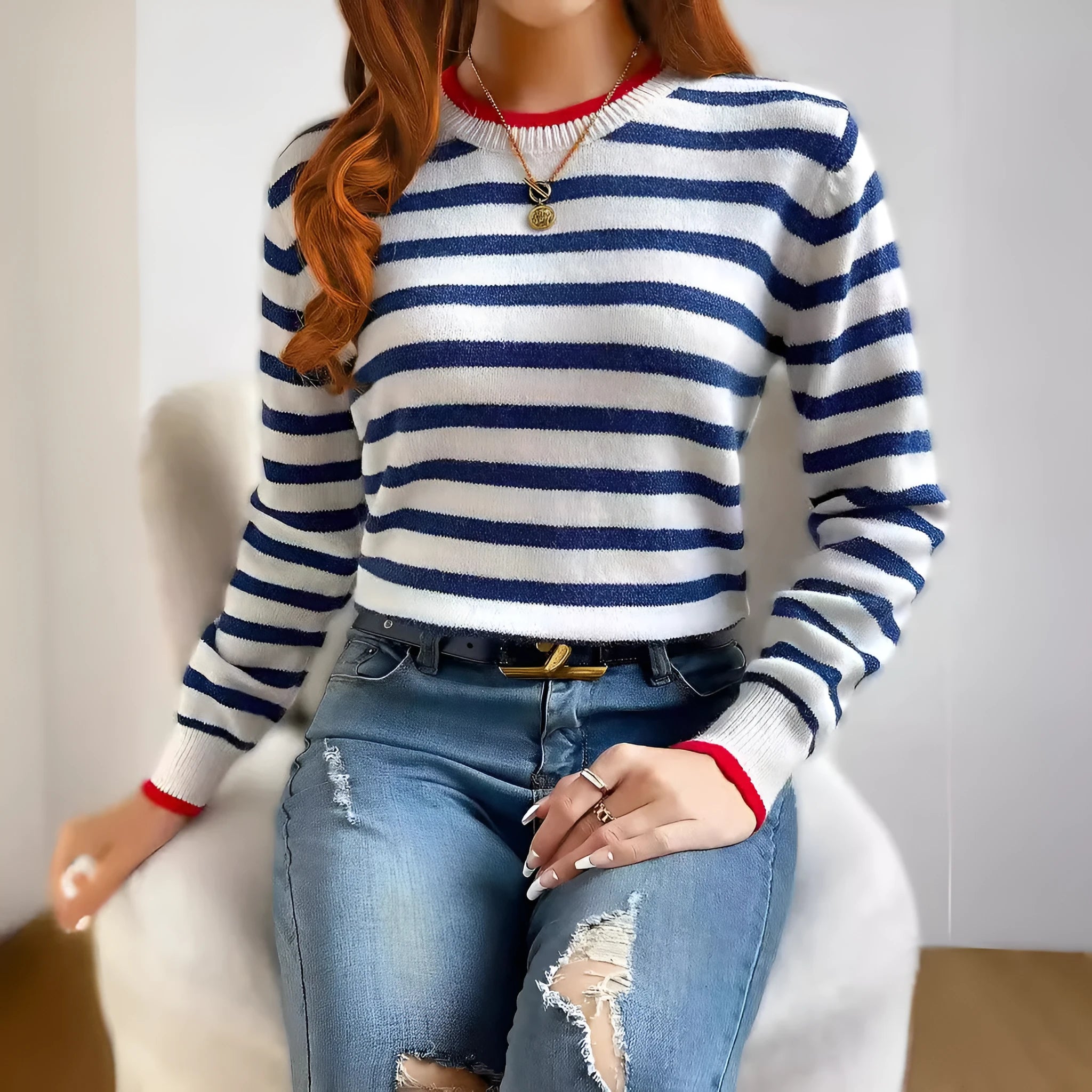 Sapphire blue striped loose fit pullover sweater with round neck and long sleeves on a hanger.