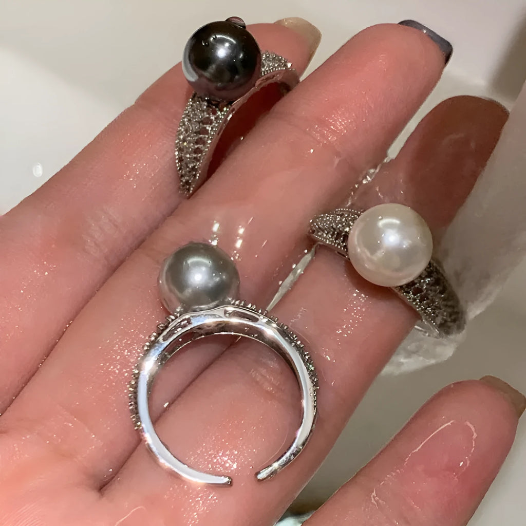 Adjustable open copper ring with geometric shape and black pearl detail on index finger