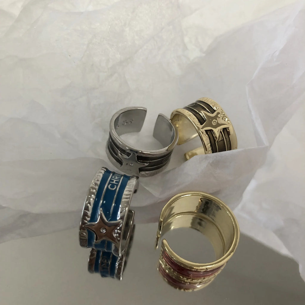 Women's adjustable copper ring with distressed XINGX drop oil design in geometric shape showing colour options