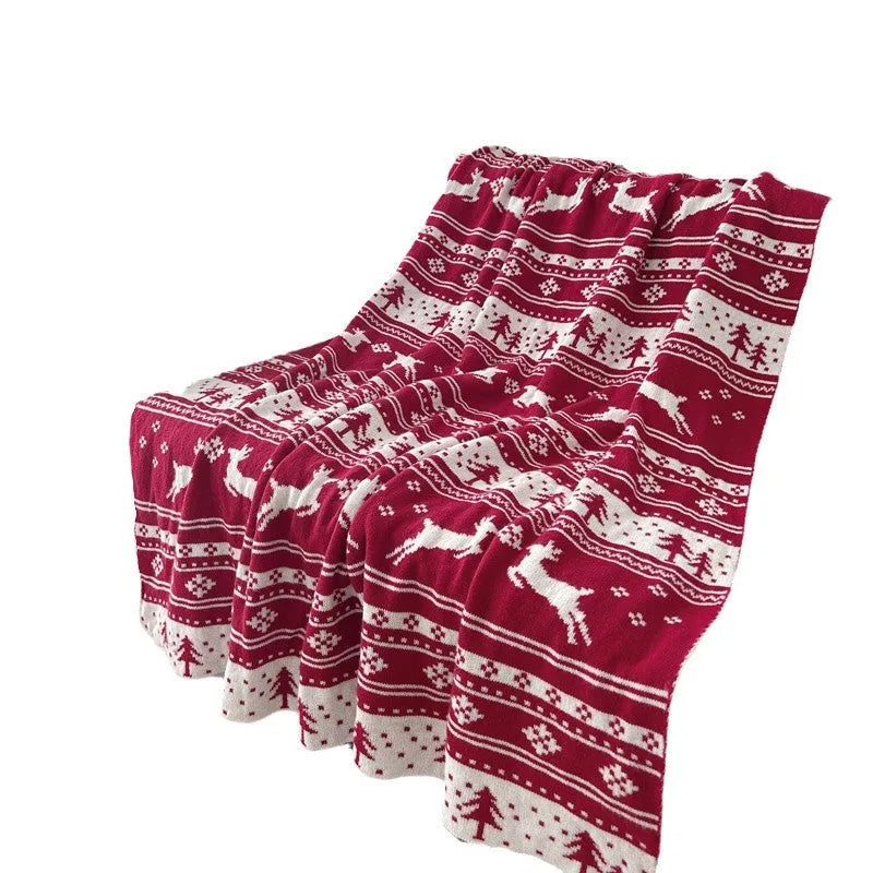 Personalised acrylic Christmas blanket with snowflake pattern draped over a sofa.