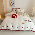 Girl's winter cartoon print bedding four-piece set with bed sheet, duvet cover, and pillowcases on a bed.