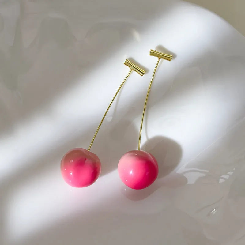 A pair of colourful acrylic peach-shaped stud earrings on a copper post, shown in small and large size options.