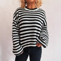 Woman wearing a black and white vintage stripe loose pullover sweater with a round neck and long sleeves.