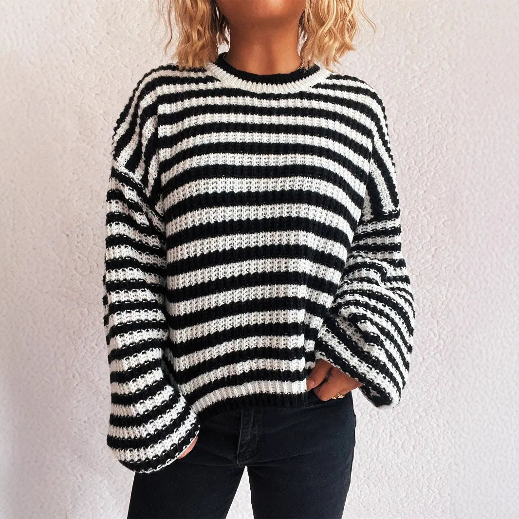 Woman wearing a black and white vintage stripe loose pullover sweater with a round neck and long sleeves.