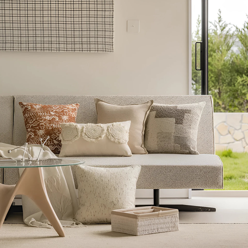 A 45cm square solid-colour cushion with stitched edges on a grey sofa.