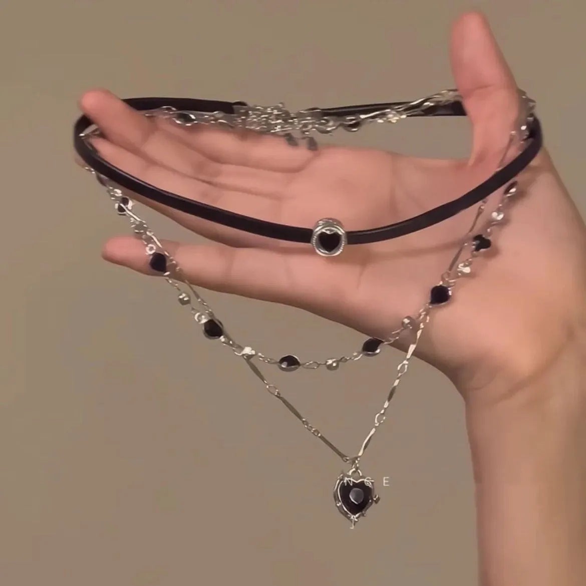 Women's twin-layer necklace with a leather-wrapped heart-shaped alloy pendant on an adjustable chain.