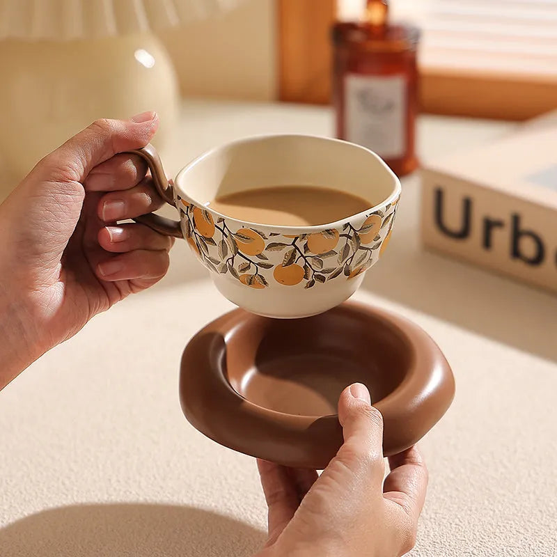 Antique style ceramic coffee cup and saucer set with medieval botanical print in black or orange.