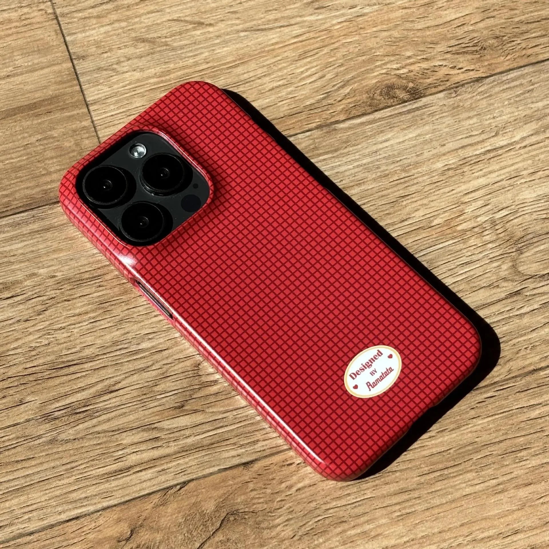 iPhone 15 Pro Max phone case with red plaid design and anti-fingerprint finish.