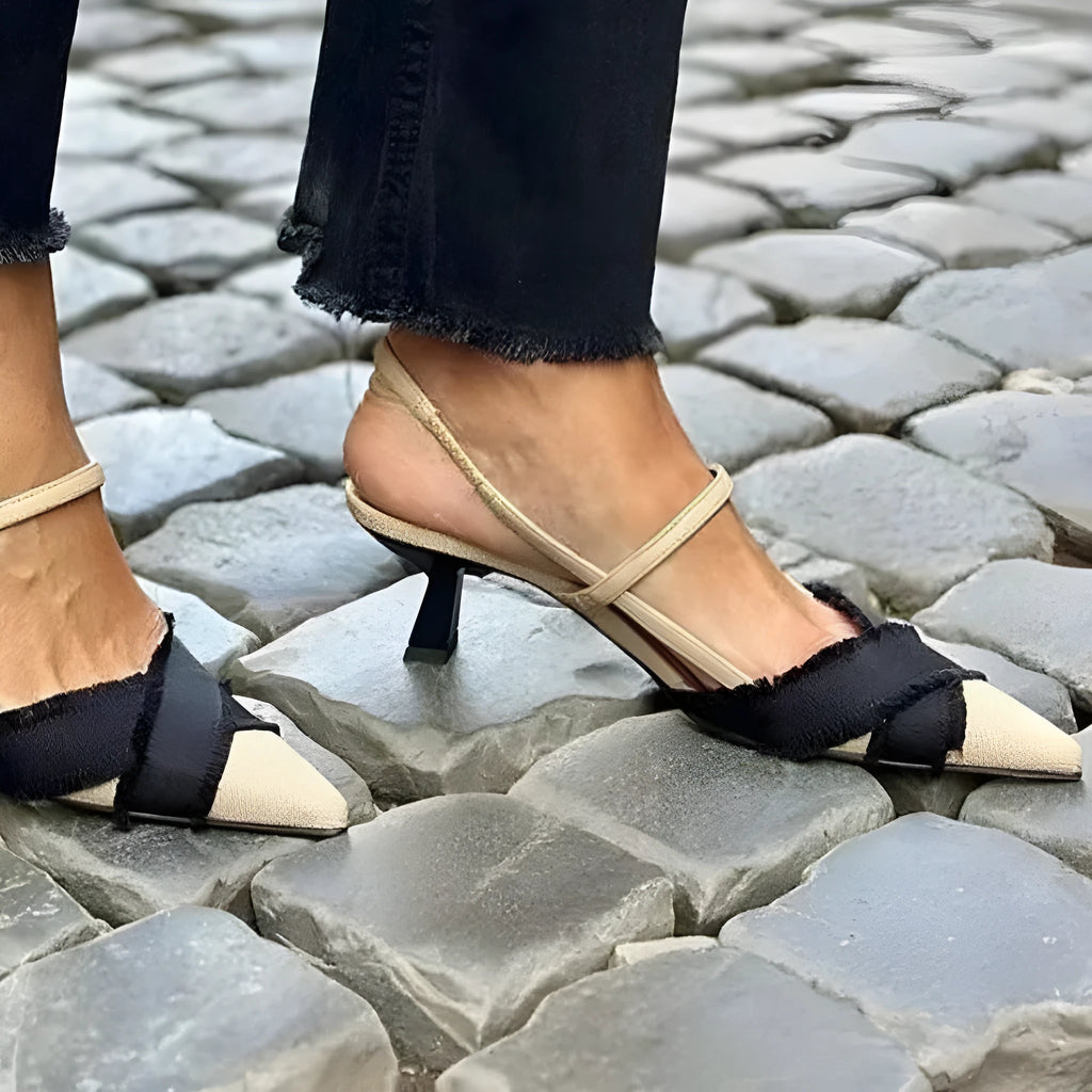 Apricot and black women's stiletto heel sandals with pointed toe and buckle fastening.