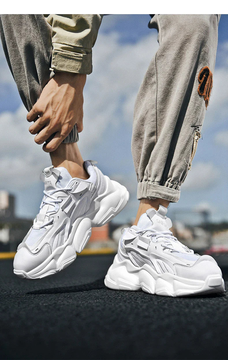 Pair of white, black, and gray casual sports sneakers with leather upper and rubber sole