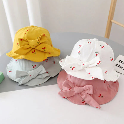 A charming bucket hat for kids featuring a delightful fruit print and cute bow detail, providing excellent sun protection and comfort.