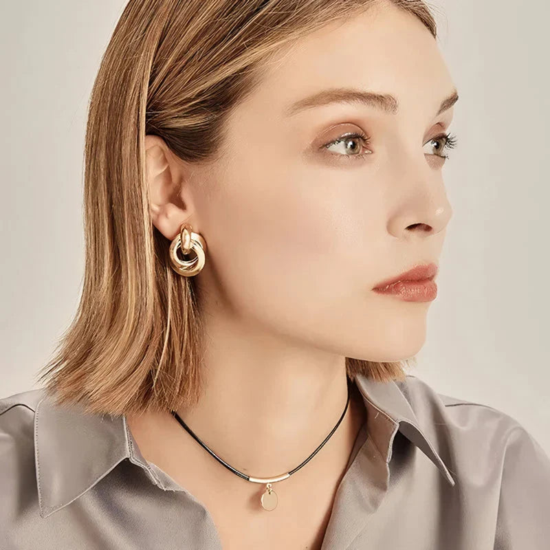 Geometric statement earrings in a luxurious gold finish, featuring a unique hollow twist design for a bold, fashionable look