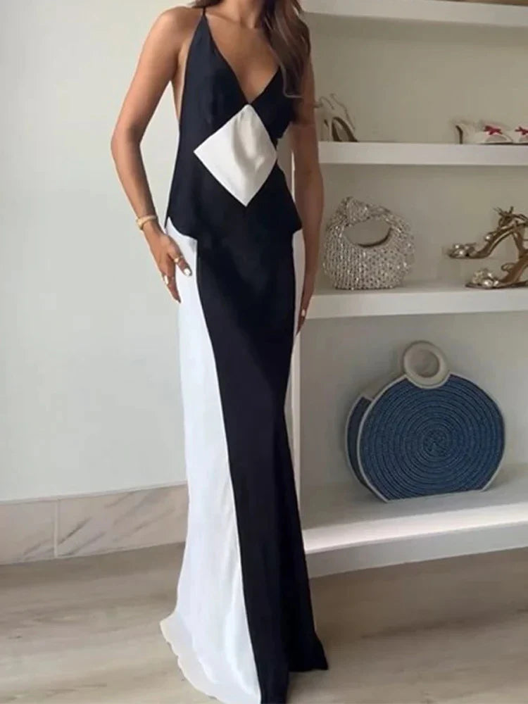 A sleeveless, long sling dress with a geometric black and white pattern, featuring an A-line silhouette and high-waist design.