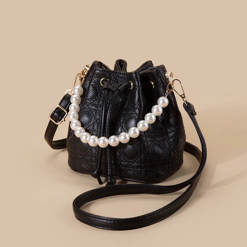 A stylish cowhide bucket handbag in cloud pearl color, featuring a modern design and versatile functionality.