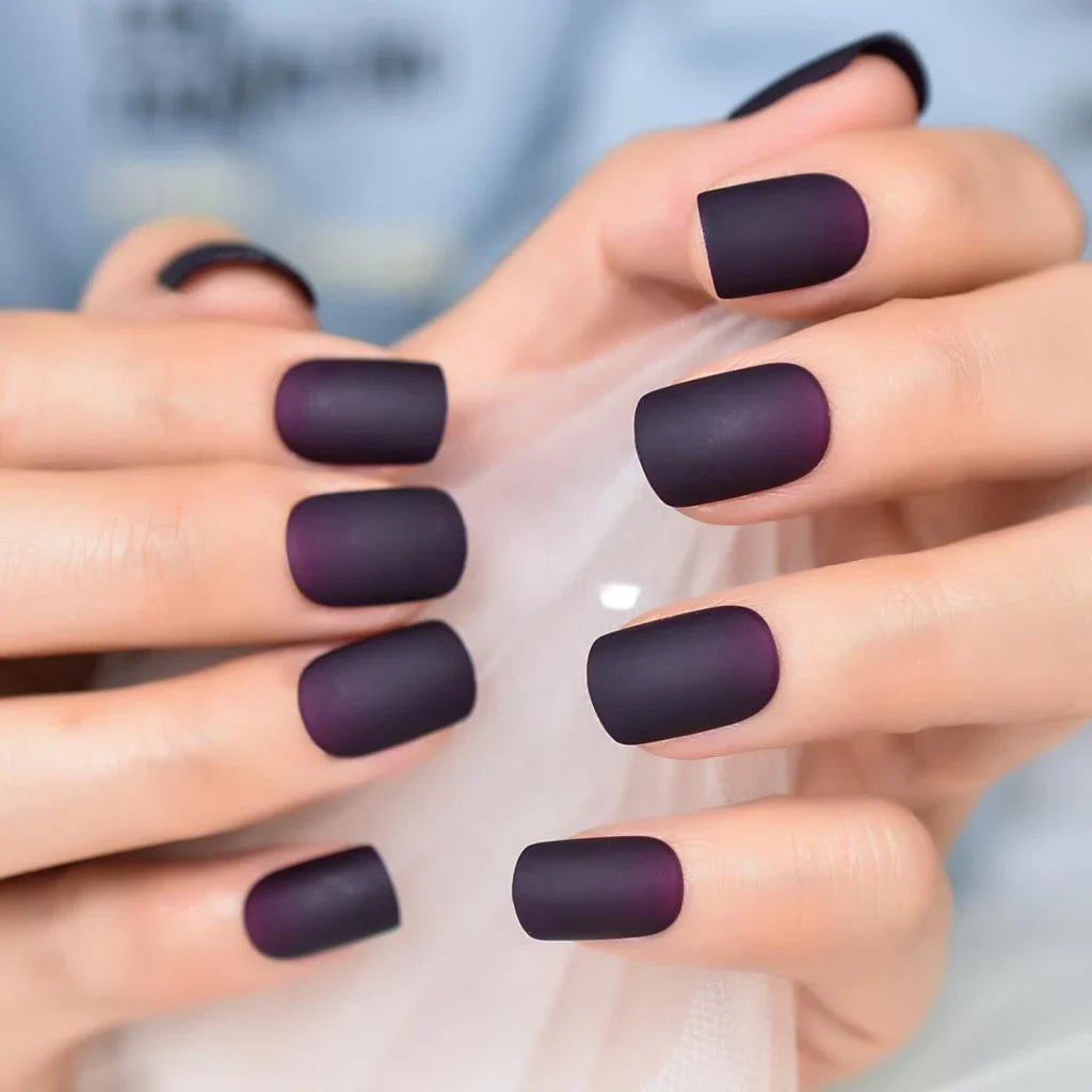 Matte purple and black squoval fake nails with a sleek, salon-quality design