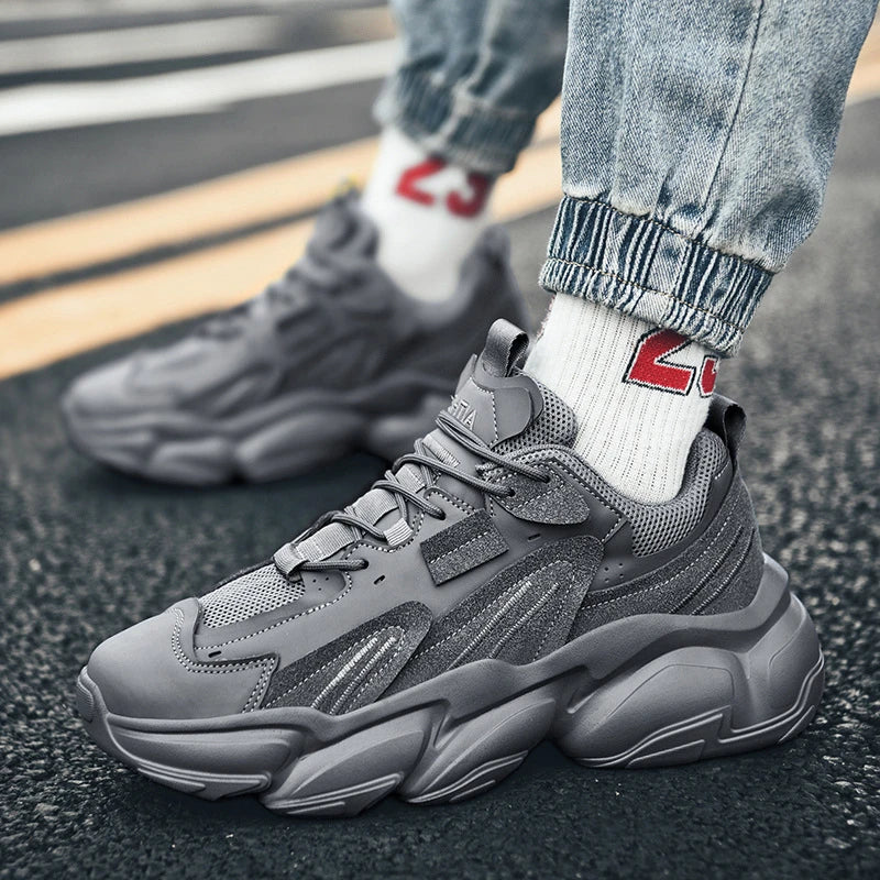 Pair of white, black, and gray casual sports sneakers with leather upper and rubber sole