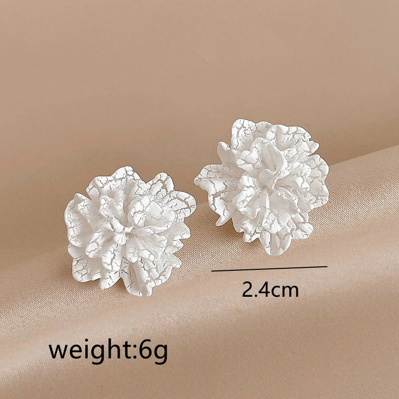 Elegant white floral stud earrings with a timeless design, perfect for adding a touch of sophistication to any Kiwi outfit.