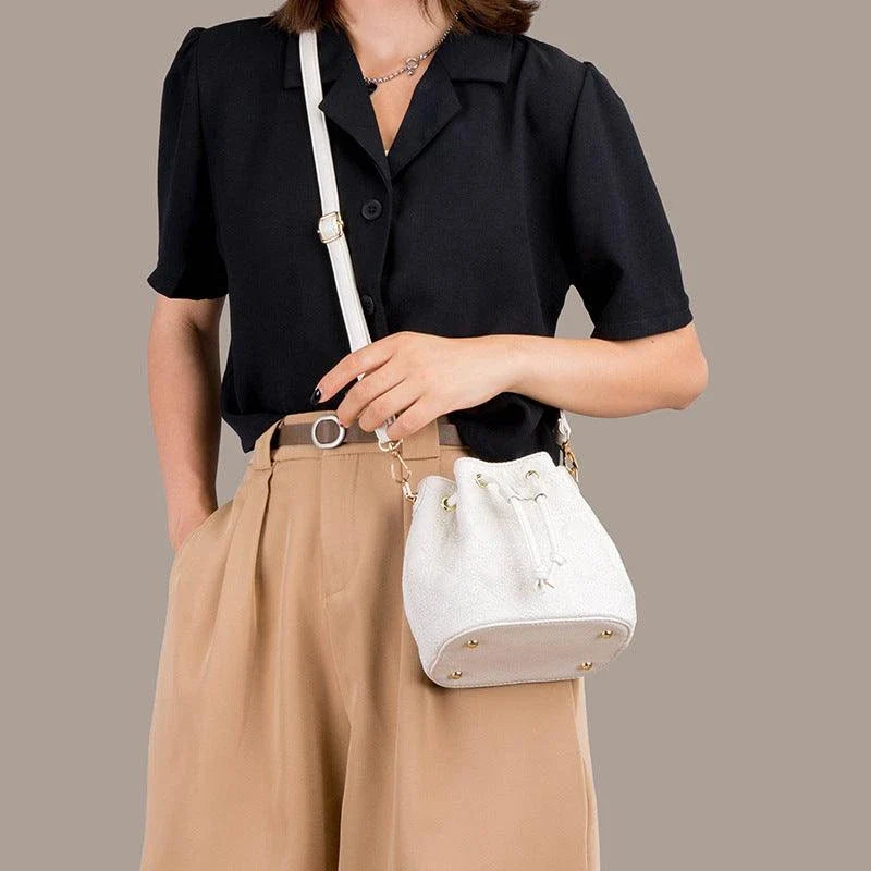 A stylish cowhide bucket handbag in cloud pearl color, featuring a modern design and versatile functionality.