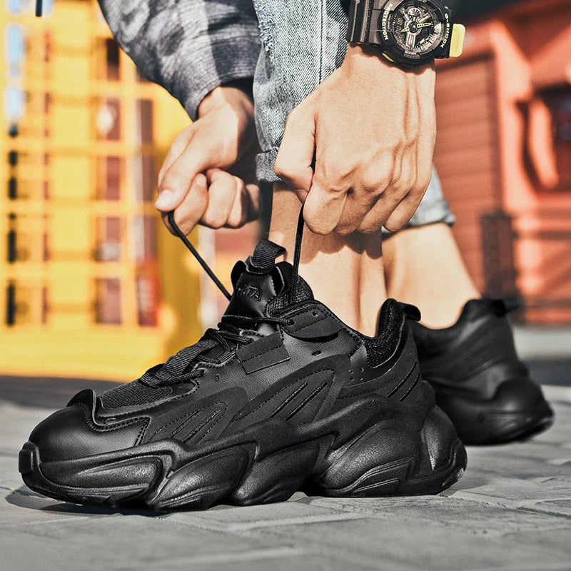 Pair of white, black, and gray casual sports sneakers with leather upper and rubber sole