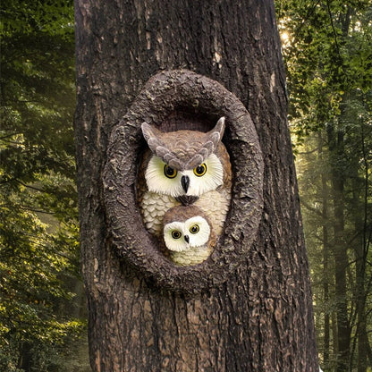 Charming resin mother and child owl ornament hanging from a tree branch in a Kiwi garden