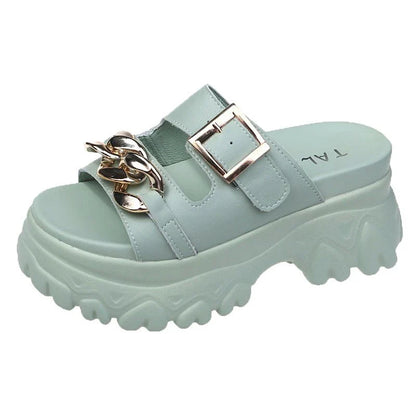 A pair of white, sponge cake-inspired sandals with a metal buckle, showcasing a unique and stylish Kiwi-inspired design.