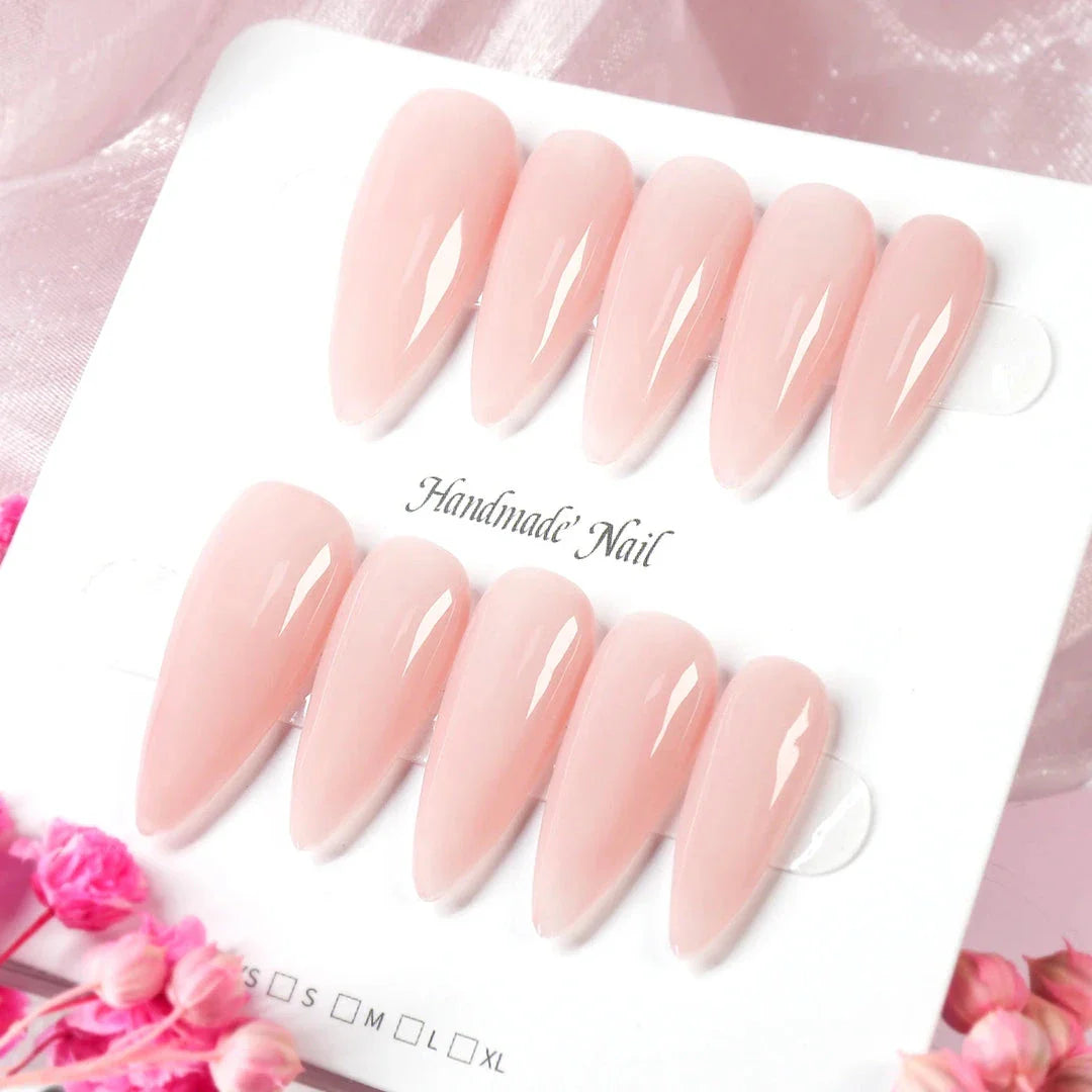 Handcrafted nude pink press-on nails with an almond shape, offering a minimalist and sophisticated style