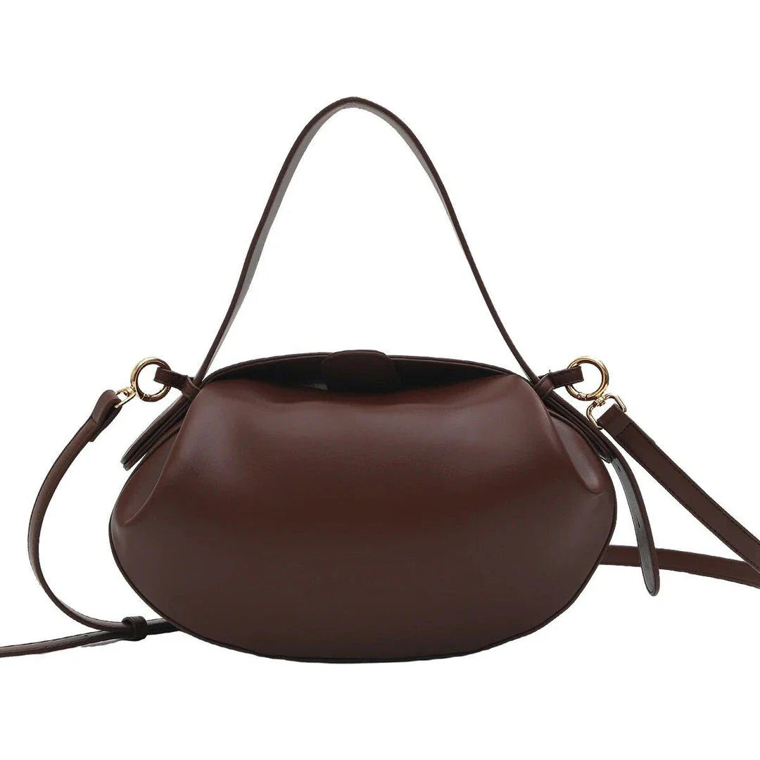 A stylish circular vegan leather handbag with a unique rugby-inspired design, perfect for Kiwi fashion enthusiasts