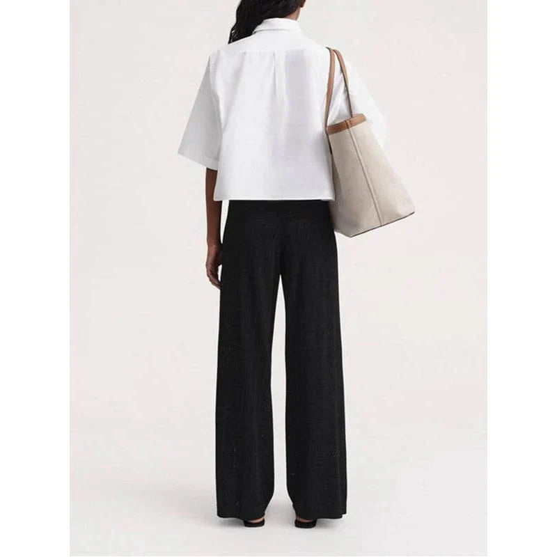 High-waist hollow-out knit trousers in a black color, featuring a straight, wide-leg cut and a sophisticated pattern