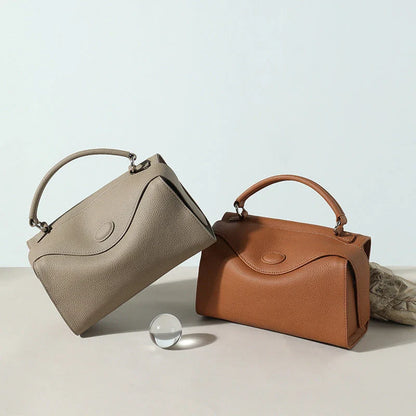 Premium cowhide leather crossbody bag with a unique pillow-shaped design, multiple interior pockets, and an adjustable strap for comfortable everyday wear.