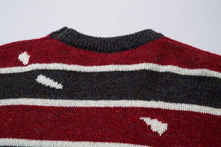 A vibrant red pullover sweater with an eye-catching patchwork stripe pattern, a cozy and stylish Kiwi wardrobe essential.