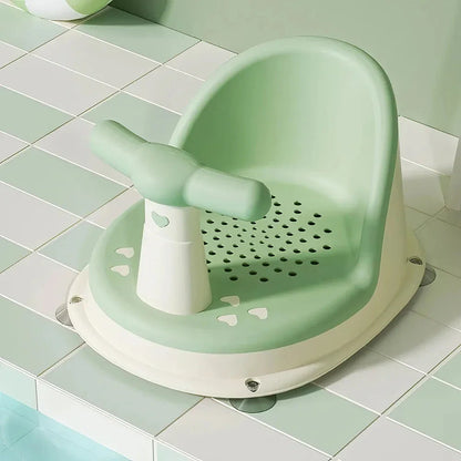 A green, ergonomically designed infant bath tub with large suction cups on the bottom to prevent slipping or tipping.