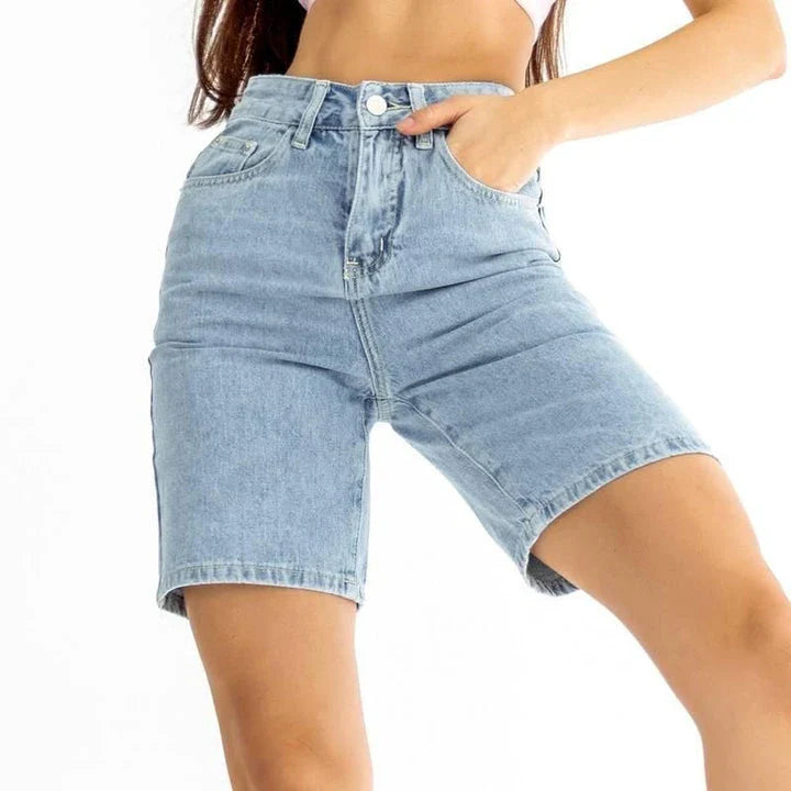 Classic blue knee-length denim shorts with high-waisted design, button fly closure, and wide-leg silhouette