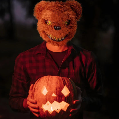 A creepy and realistic plush bunny mask with long pink ears, a bloody mouth, and glowing green eyes - perfect for Halloween and costume parties.