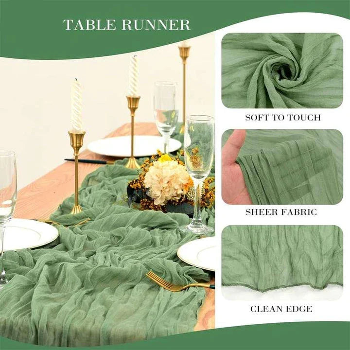 A green boho-style cheesecloth table runner with a delicate, wrinkled texture that adds a touch of elegant charm to any table setting.