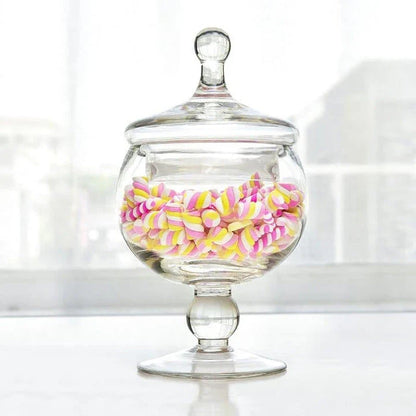 A transparent glass candy jar with a secure lid, perfect for serving sweets and treats at a wedding celebration.