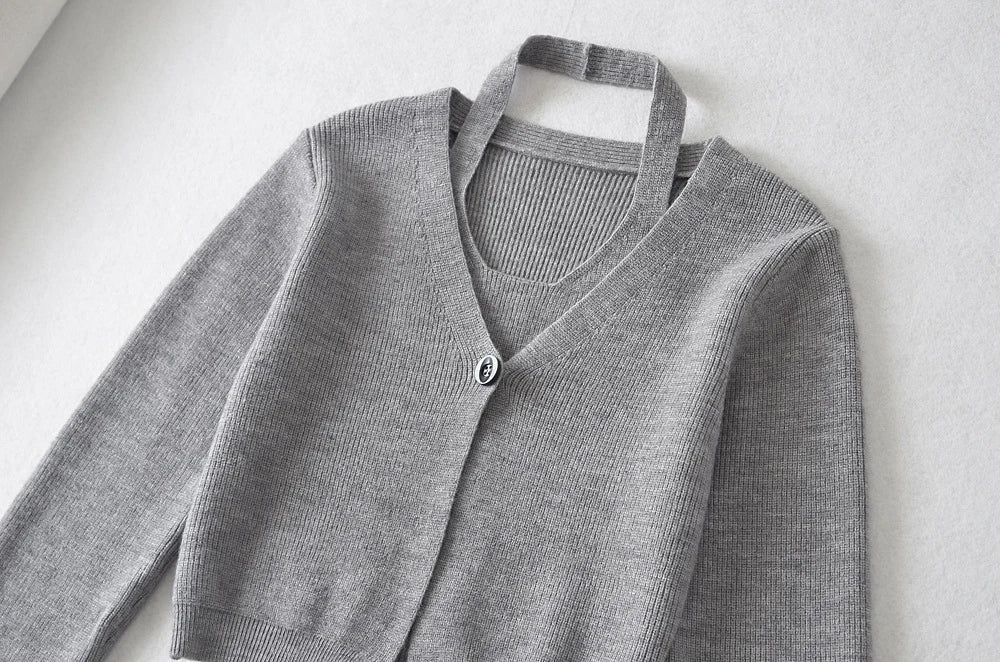 Stylish knitwear vest in a classic black or neutral colour, featuring a V-neck collar and long sleeves for a polished, versatile look.