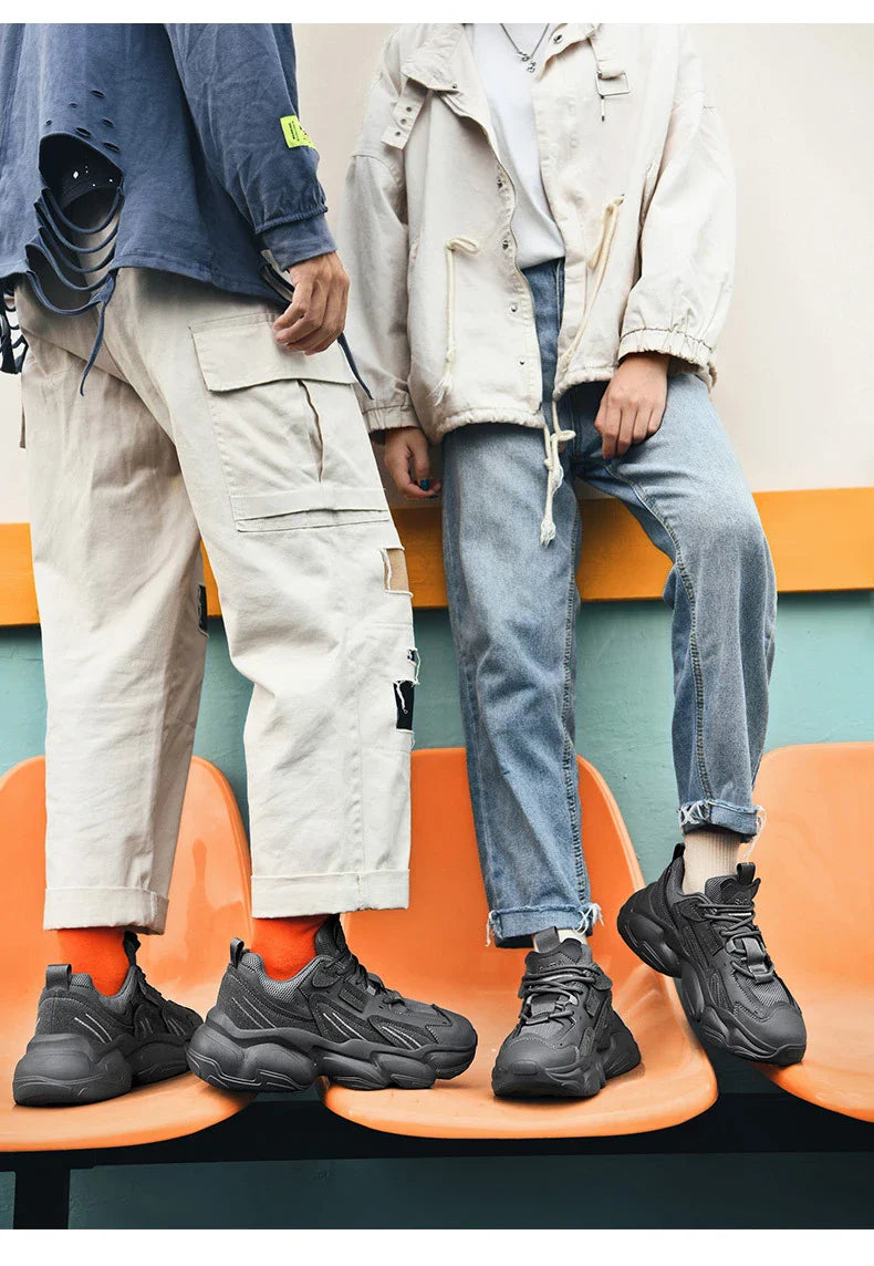 Pair of white, black, and gray casual sports sneakers with leather upper and rubber sole