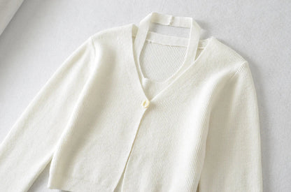 Stylish knitwear vest in a classic black or neutral colour, featuring a V-neck collar and long sleeves for a polished, versatile look.