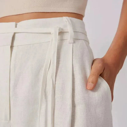 Elegant high-waist linen trousers with Korean-inspired design, featuring lace-up detail and button decorations for a sophisticated and comfortable look.