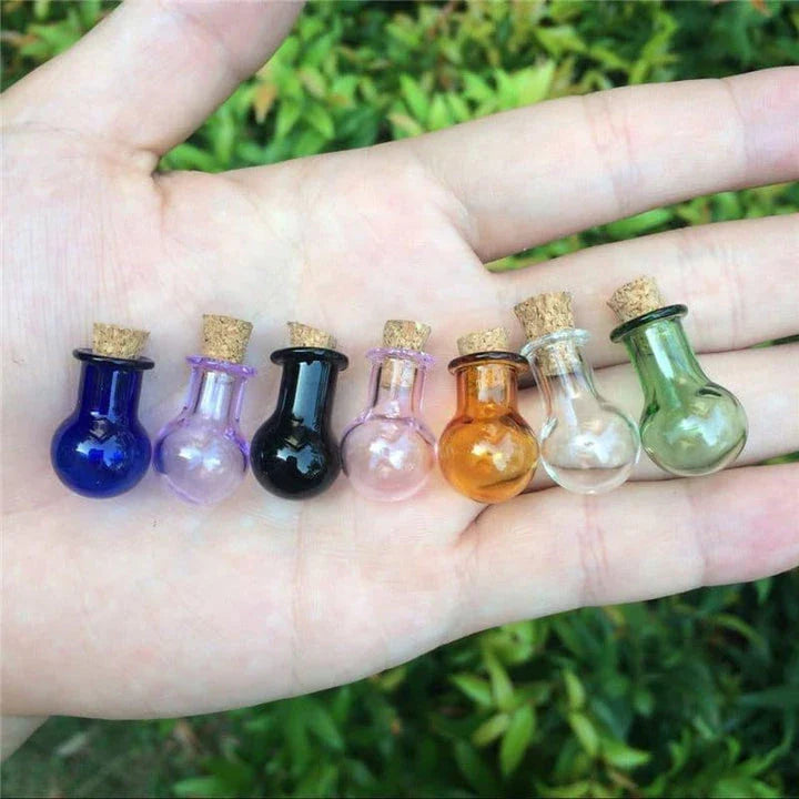 Multicoloured mini glass bottles in a stylish ball shape, perfect for essential oils, trinkets, and decorative accents.