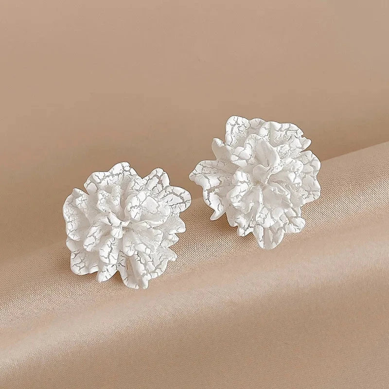 Elegant white floral stud earrings with a timeless design, perfect for adding a touch of sophistication to any Kiwi outfit.