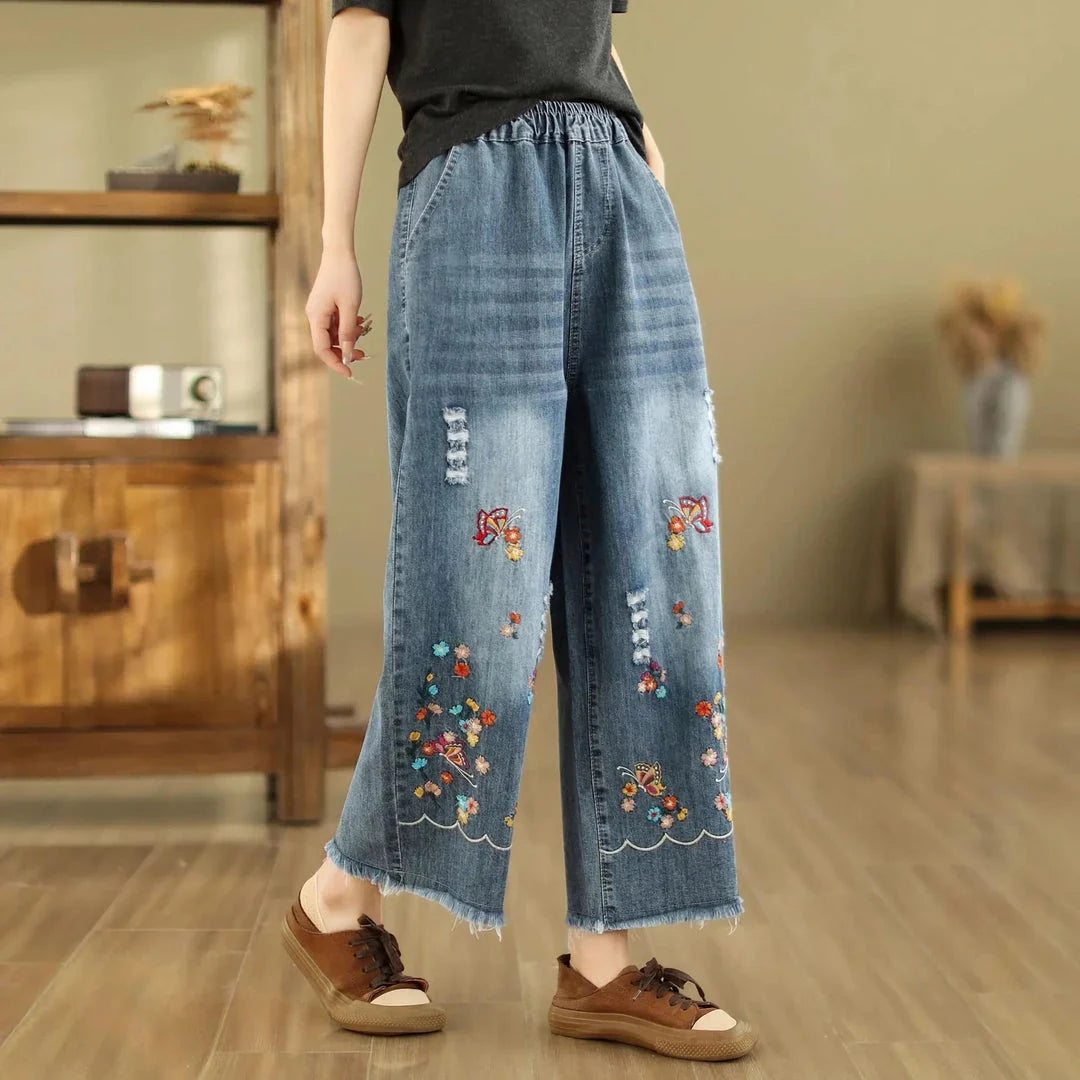 Embroidered wide-leg denim pants with a high-waist design and elastic closure, perfect for Kiwi fashion.