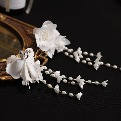 Elegant white floral ear clip with three-dimensional camellia flower and lily of the valley bud