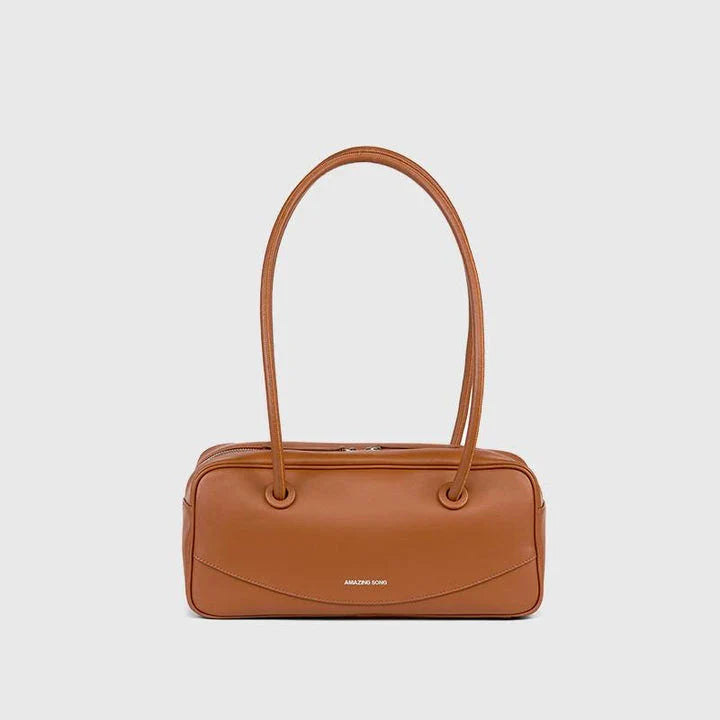 Premium split leather shoulder bag in a baguette shape with a smiley face design, perfect for Kiwis on the go.