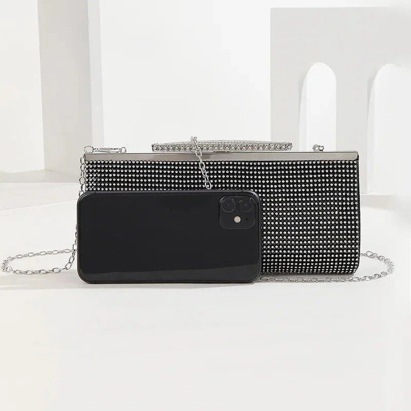 A glamorous gold rhinestone-embellished evening clutch with a sleek, hard exterior and fashionable hasp closure.