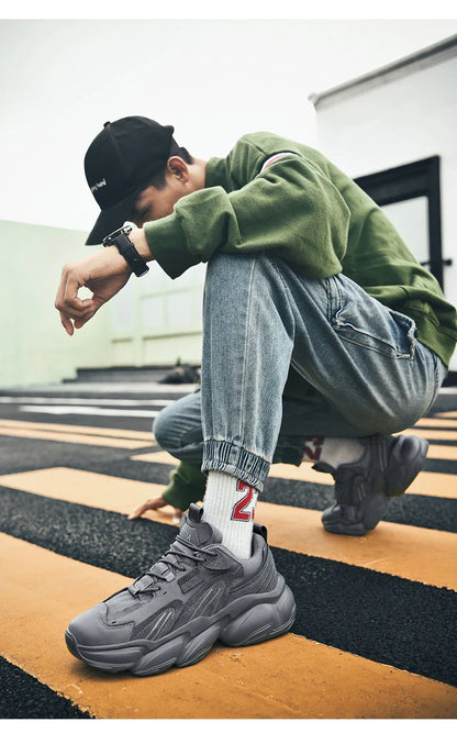 Pair of white, black, and gray casual sports sneakers with leather upper and rubber sole