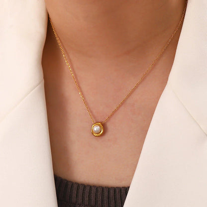 Elegant stainless steel necklace with a unique, irregular pearl pendant in a gold color, featuring a contemporary geometric design